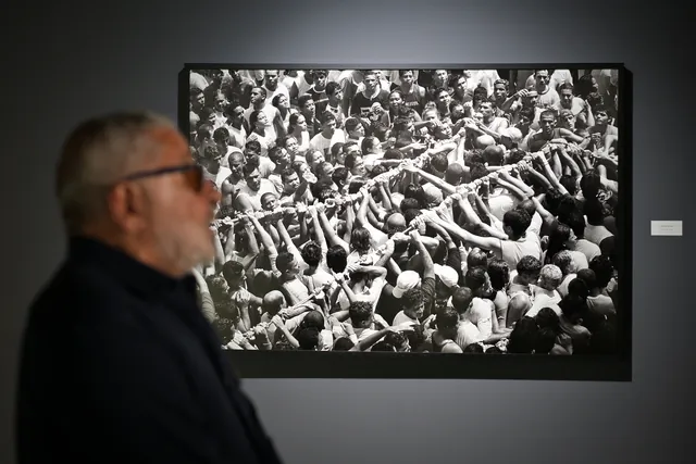 Araquém Alcântara de perfil ao lado da fotografia de uma multidão em preto e branco.